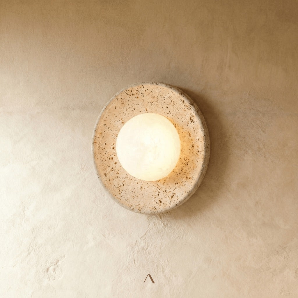 Golden travertine table lamp with a frosted glass orb, showing the stone's natural grain and markings under warm light